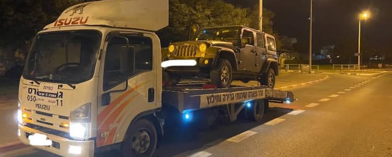 גרר משטח איסוזו של גרר פארס עם ג׳יפ, בלילה
